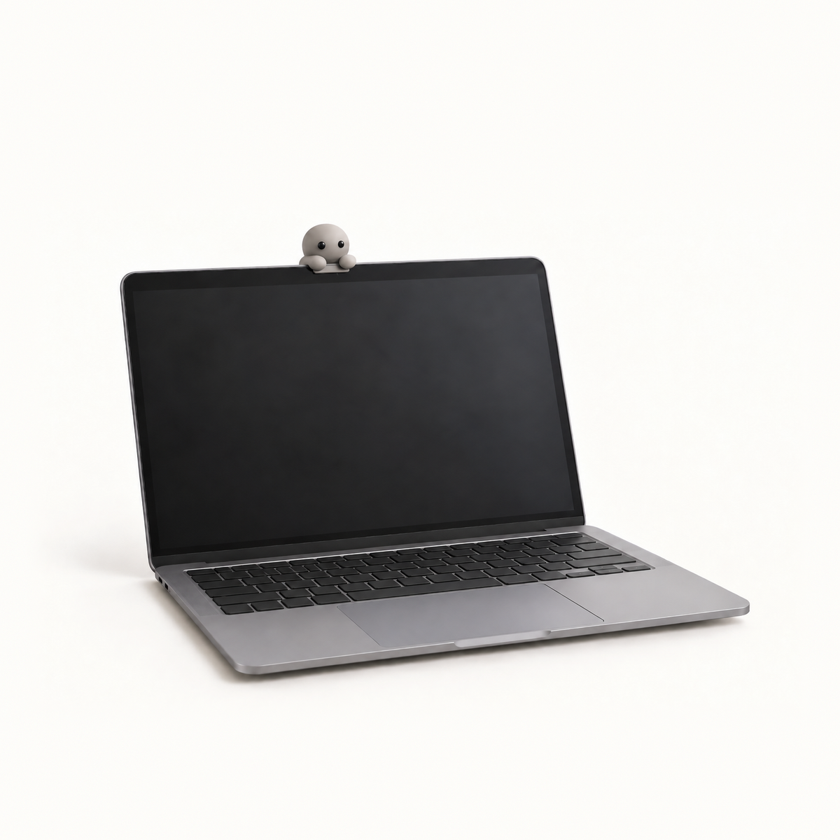 The MacBook Perch in the Stone colourway, a slim matte grey ledge on a laptop lid, with a Corbie peeking over its edge at the owner.